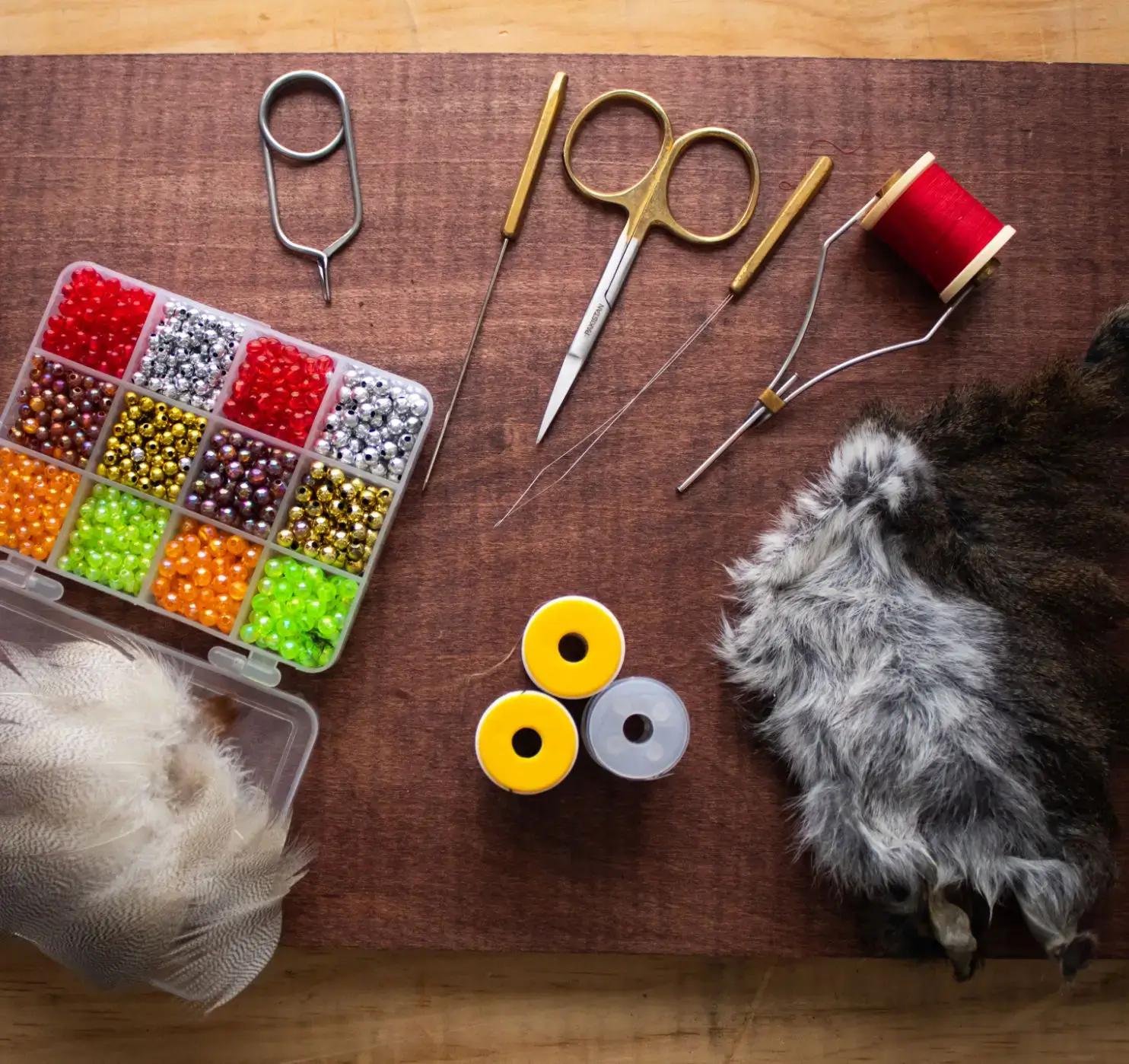 Fly tying tools and materials on table.